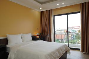 um quarto com uma cama grande e uma janela grande em Dolce Mia Home Ninh Bình em Ninh Binh