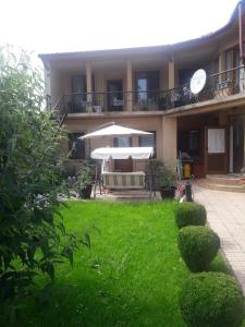 a house with a green yard with an umbrella at Casa da affittare in centro citta in Ploieşti