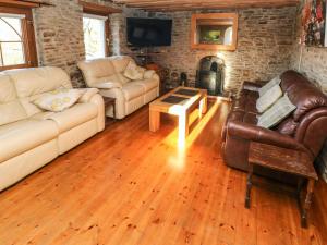a living room with leather furniture and a fireplace at Nant Moel Isaf Farm in Swansea