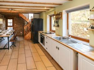 a kitchen with a sink and a refrigerator at Nant Moel Isaf Farm in Swansea