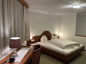 a hotel room with a bed and a desk and a bed and a desk at Aparthaus Camping Stubai in Neustift im Stubaital