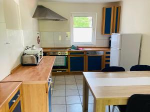 a kitchen with blue cabinets and a white refrigerator at Clarkes Apartments in Leopoldshöhe