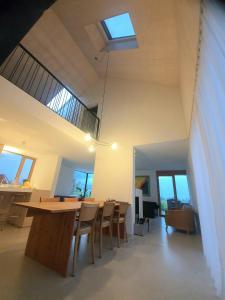 a dining room with a table and chairs and a skylight at Urban Mountain Chalet with Lake View in Maurach