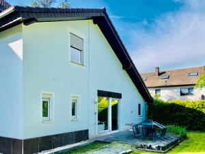 a white house with a patio and a table at Clarkes Apartments in Leopoldshöhe