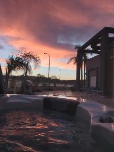 a hot tub with a sunset in the background at Villa Tzukim Mitzpe Ramon in Mitzpe Ramon