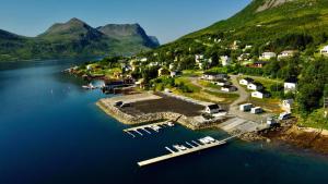 - une vue aérienne sur un petit complexe au bord d'un lac dans l'établissement Senja Fjordcamp, à Torsken