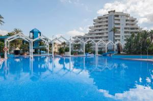een groot zwembad met een groot gebouw op de achtergrond bij VIVE BENALMÁDENA Apartamento BENAL BEACH 510 Vistas al mar, PARQUE ACUÁTICO in Benalmádena