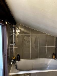 La salle de bains est pourvue d'une baignoire et de carrelage. dans l'établissement Pépite rare 8 personnes au cœur battant du Vieux Lyon, à Lyon