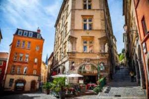 une rue de la ville avec deux bâtiments et un parasol dans l'établissement Pépite rare 8 personnes au cœur battant du Vieux Lyon, à Lyon