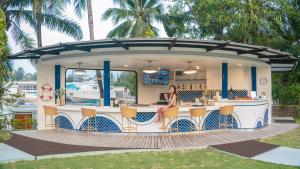 a woman sitting at a bar on a deck at NH Boat Lagoon Phuket Resort in Phuket