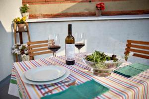 einen Tisch mit einer Flasche Wein und einer Schüssel Salat in der Unterkunft Palomar de Corrida Atico con terraza in Gijón