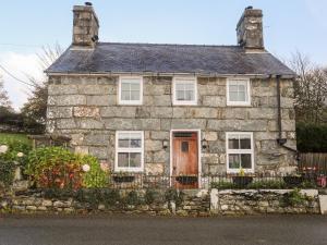 an old stone house with a red door at Ty'n y Clawdd in Dyffryn
