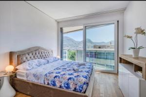 um quarto com uma cama e uma grande janela em 5 Rent Apartments Lugano Station em Lugano