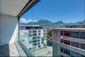 uma varanda com vista para um edifício em 5 Rent Apartments Lugano Station em Lugano