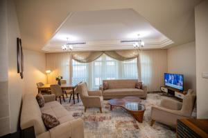 uma sala de estar com sofás, uma televisão e uma mesa em Niamey Mall & Residence em Niamey
