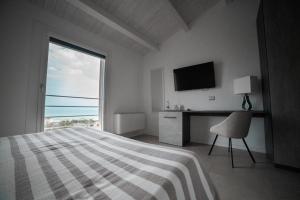 Dormitorio con cama, escritorio y TV en Agriturismo Il Colle Dei Lecci, en Ancona