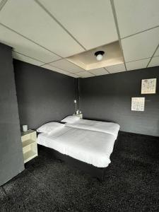 a bedroom with a large white bed in a room at Hotel de Raket in Rogat