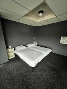 a large bed in a room with a black wall at Hotel de Raket in Rogat