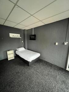 ein kleines Schlafzimmer mit einem Bett in einem Zimmer in der Unterkunft Hotel de Raket in Rogat