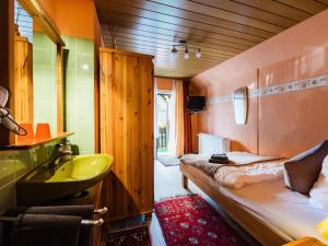 ein Bad mit einem Waschbecken und ein Bett in einem Zimmer in der Unterkunft Haus Sabine - Familienzimmer 1 in Braunlage