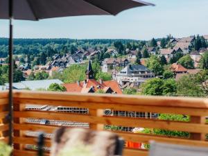uma vista para uma cidade a partir de uma varanda com um guarda-sol em Hillside Braunlage em Braunlage
