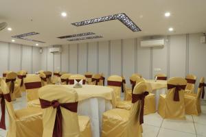 a banquet hall with tables and chairs with bows at Hotel Gurugram in Gurgaon