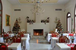 una sala da pranzo con alberi di Natale e camino di Grand Hotel Di Lecce a Lecce