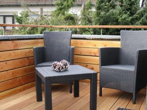 2 chaises et une table sur une terrasse dans l'établissement Chalet Platzhirsch, à Braunlage