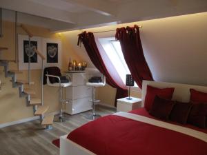 a bedroom with a red bed and a staircase at Chalet Platzhirsch in Braunlage