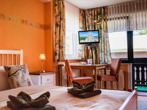 a bedroom with a bed and a desk and a television at Zimmer Nr 2 im Haus Sabine in Braunlage