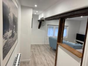 a living room with a blue couch and a television at Chantignolle, proche aéroport in Tillé +4 photos