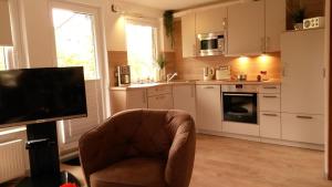 a kitchen with a chair and a tv in a room at Ole's BergSuite in Braunlage