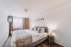 ein weißes Schlafzimmer mit einem Bett und einem Fenster in der Unterkunft Wolfswarte in Braunlage