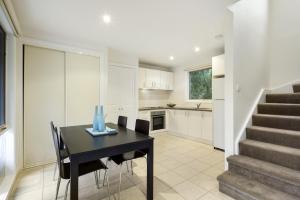a kitchen and dining room with a black table and chairs at Briars Cottage - Daylesford in Daylesford