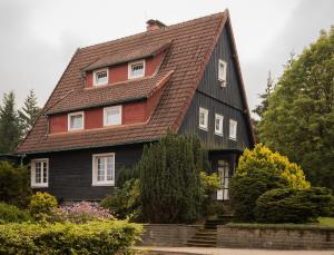 czarno-czerwony dom z brązowym dachem w obiekcie HarzHaus Hahnenklee w mieście Hahnenklee-Bockswiese