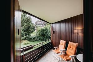 een balkon met 2 stoelen en uitzicht op een huis bij Harz Zeit Braunlage in Braunlage