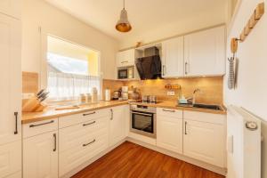 a kitchen with white cabinets and a window at Hyggeglück Braunlage in Braunlage +13 photos