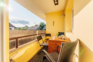 a balcony with a desk and chairs on a yellow wall at Hyggeglück Braunlage in Braunlage