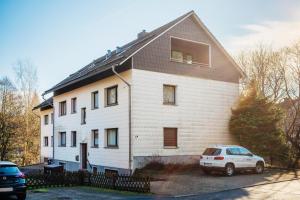 a white house with a car parked in front of it at Fichte in Braunlage