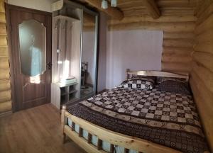 1 dormitorio con 1 cama en una cabaña de madera en "Бджілка" і " Садиба для відпочинку", en Lyuta