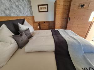duże łóżko w pokoju z drewnianymi ścianami w obiekcie klein&fein w Neustift im Stubaital