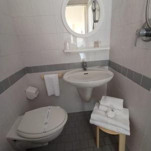 a white bathroom with a toilet and a sink at Hotel Cà Vanni in Rimini