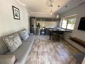 uma sala de estar com um sofá e uma cozinha em Guest house on Gillian Unit 1 em Ballito