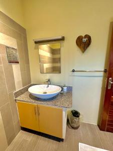 a bathroom with a sink and a heart on the wall at Seaside Self Catering in Mahe