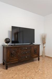 un centro de entretenimiento de madera con TV de pantalla plana en la parte superior en Magnifico apartamento en Burriana, en Burriana
