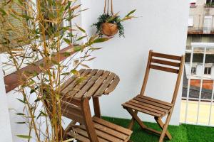 uma cadeira de madeira ao lado de uma mesa e uma planta em Ultreia , piso turístico termal em Ourense