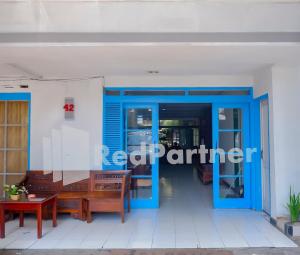 a entrance to a restaurant with blue doors and a table at Graha Sartika Hotel RedPartner in Bandung