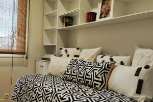 um quarto com almofadas pretas e brancas e uma cama em Ultreia , piso turístico termal em Ourense