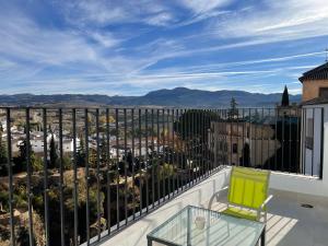 a balcony with a glass table and a view of a city at Apartamentos Casa-Palacio Santa Pola in Ronda