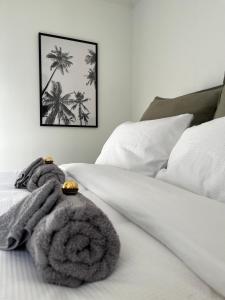 a bed with a blanket and a picture of palm trees at - Welcome Home - 3brm Character, Close to Everything in Hamilton